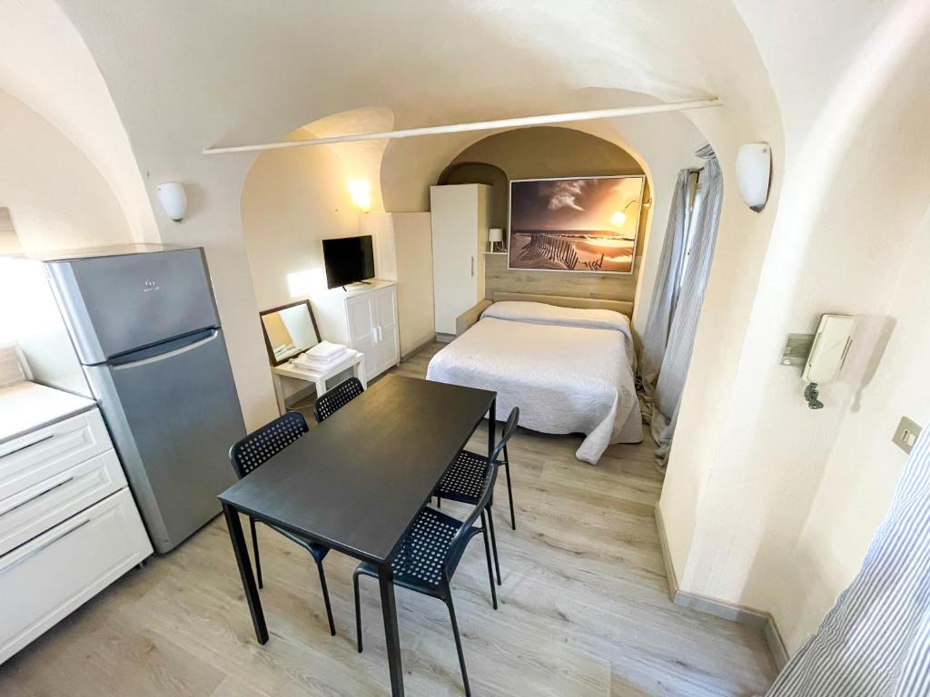Camera piccola con letto, tavolo e sedie di Monolocale a 50 metri dal mare a Celle Ligure