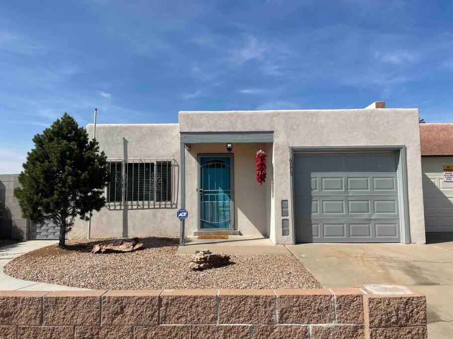 a house with a garage and a dog laying in the driveway at Comfy, contemporary quiet retreat vacation home with views in Albuquerque