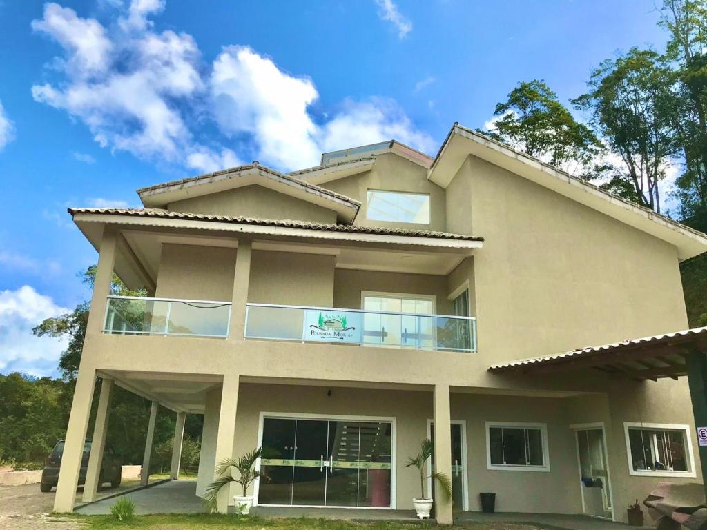 a large house with a blue sky in the background at Pousada Moriah 700 metrôs Magic City in Suzano