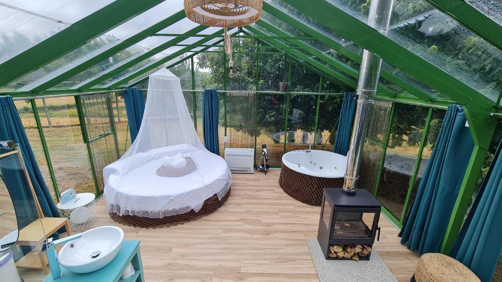 a greenhouse with a bed and a tub in it at REMANSO DE TRASFONTAO_Nido 360° in Silleda