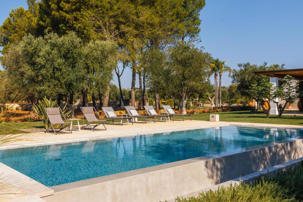 basen z leżakami i drzewami w obiekcie Pietra e Calce With Pool w mieście Ostuni
