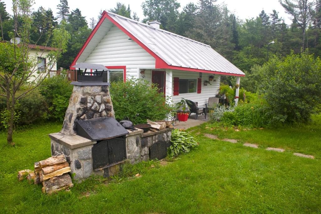 een huis met een bakstenen oven in een tuin bij Chalet Le Semeur in Saint Elie