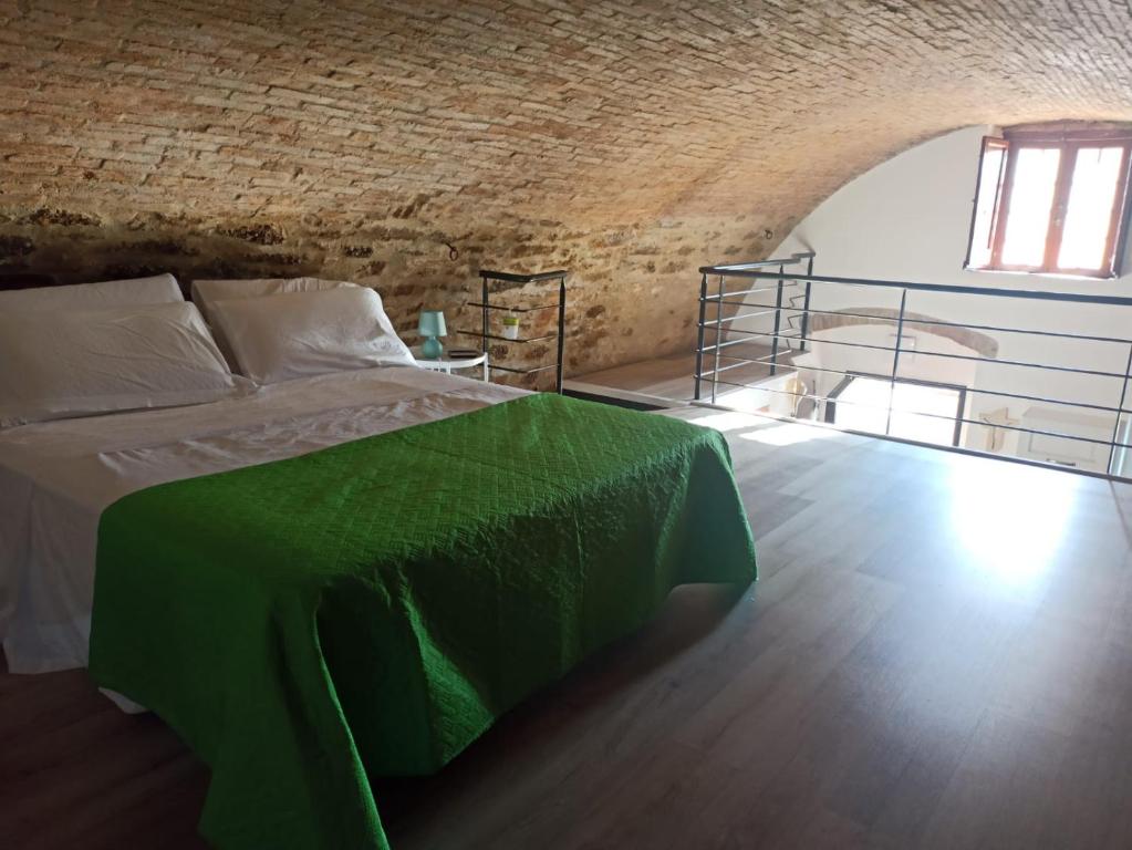 um quarto com uma cama com um cobertor verde em Matalena em Pomarico