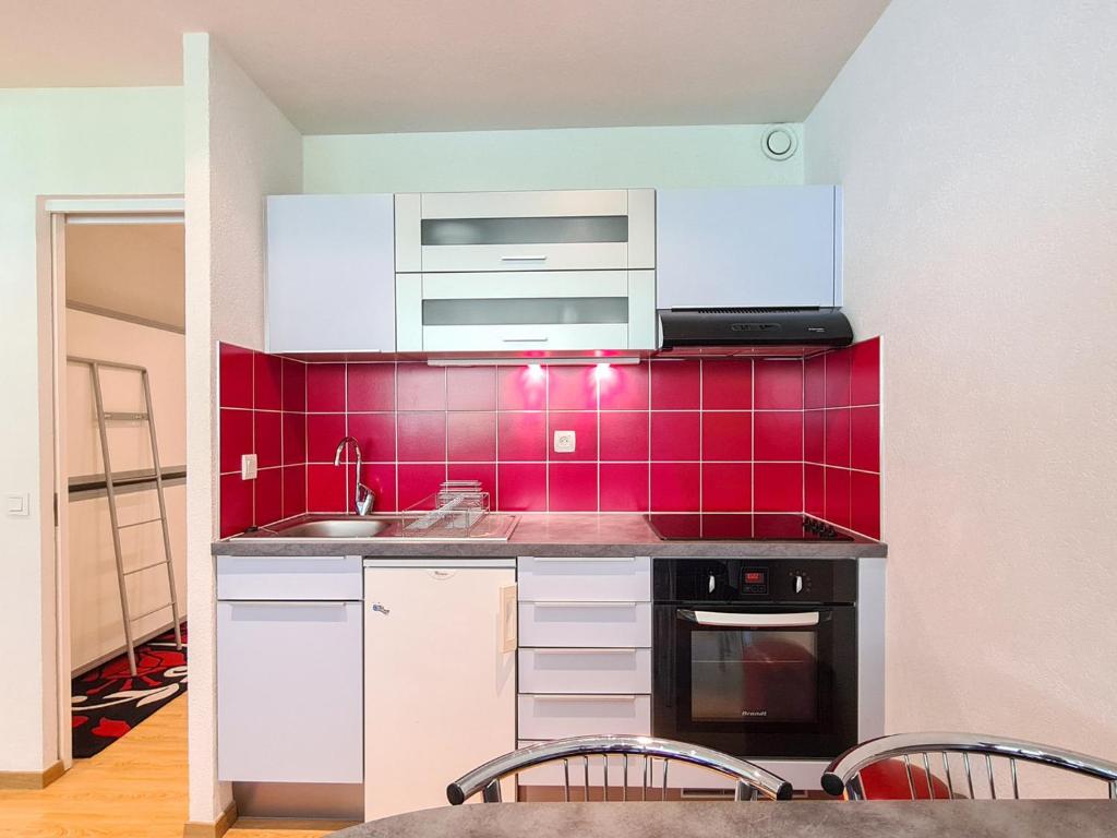 Il comprend une cuisine avec un évier et un mur en carrelage rouge. dans l&#39;établissement Studio Flaine, 1 pièce, 4 personnes - FR-1-425-167, à Flaine