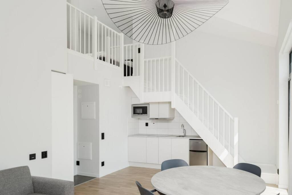 Habitación blanca con mesa y escalera en SK67 Stylish and Full Equipped loft with free parking en Lidingö