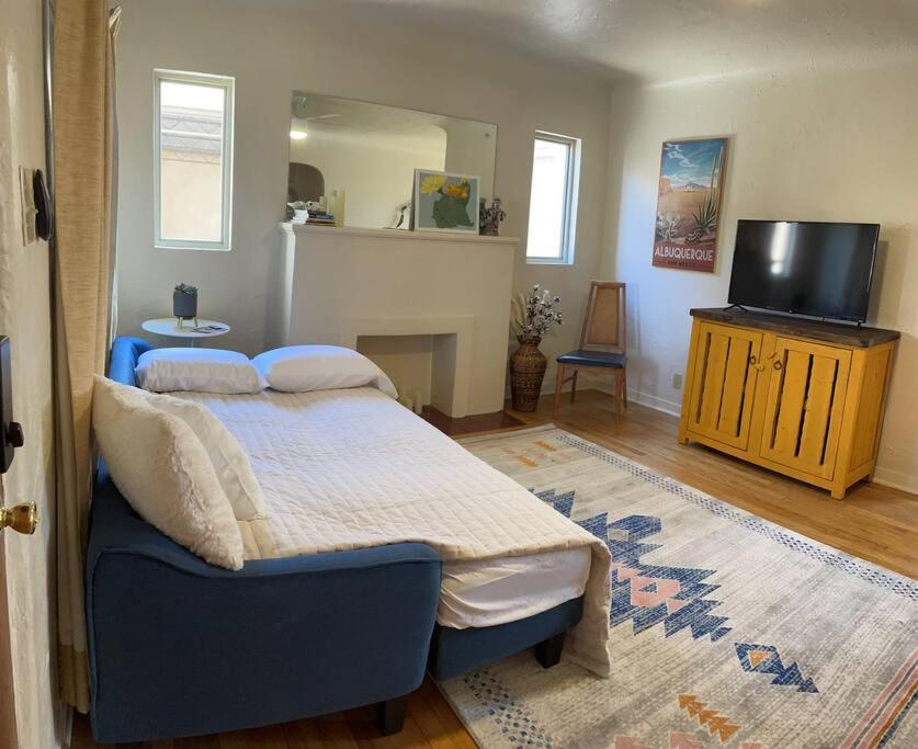 um quarto com uma cama e uma televisão de ecrã plano em Vintage charm vacation home with modern comforts near Old Town em Albuquerque
