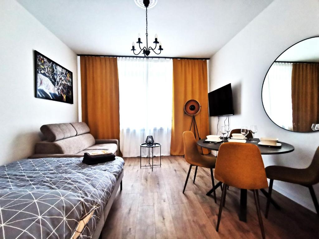 a bedroom with a bed and a desk and a table at PODWALE Apartment - Self Check-In 24h in Wrocław