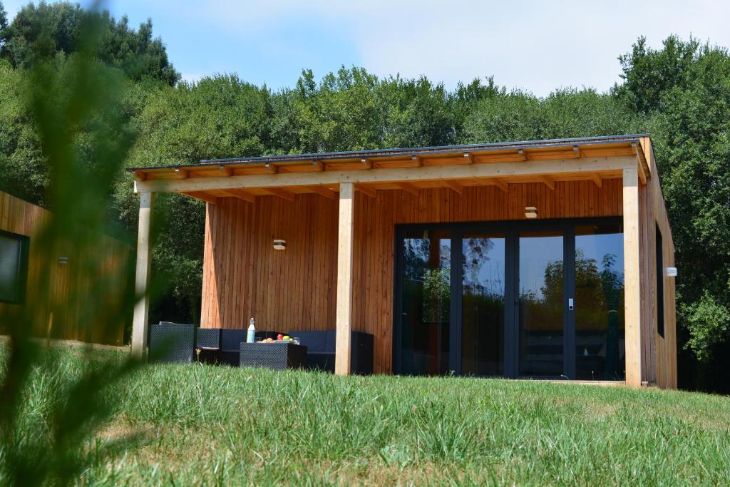 een gebouw met een grote glazen deur in een veld bij Cabañas Compostela - Cabaña Sarela in Santiago de Compostela