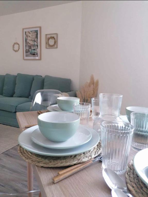 une table avec des bols, des assiettes et des verres dans l'établissement Hyper centre - Proche airbus - Tout confort - Magnifique terrasse, à Tournefeuille