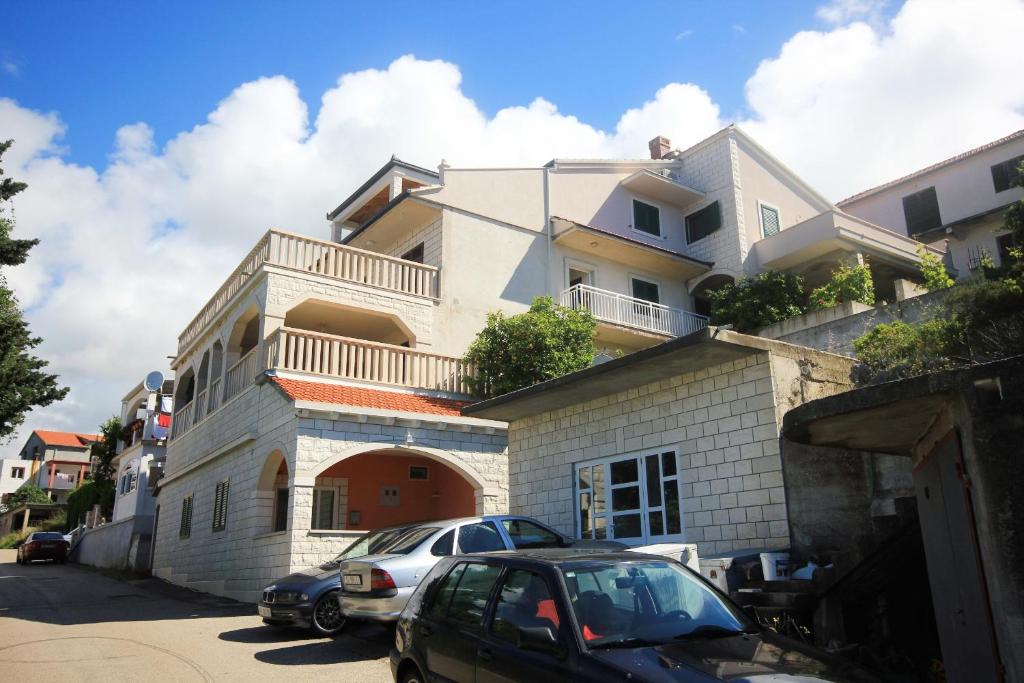 a white house with cars parked in front of it at Apartments with parking space Zavalatica, Korcula - 545 in Zavalatica