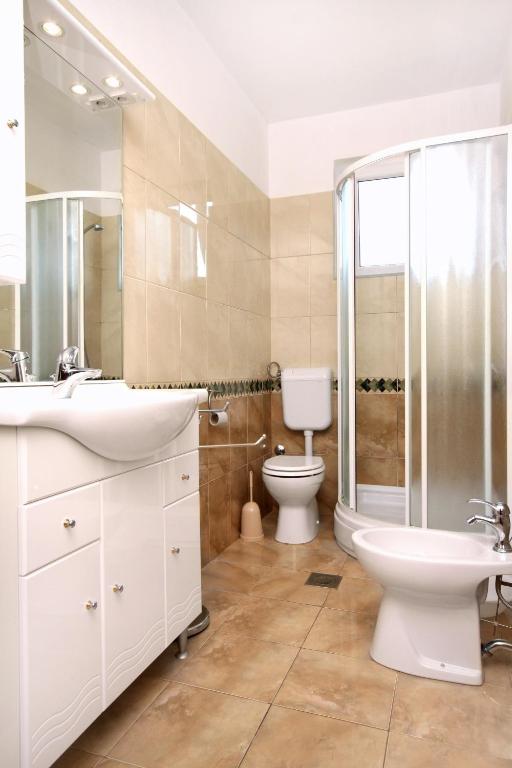 łazienka z toaletą, umywalką i prysznicem w obiekcie Apartments by the sea Pag - 529 w mieście Pag
