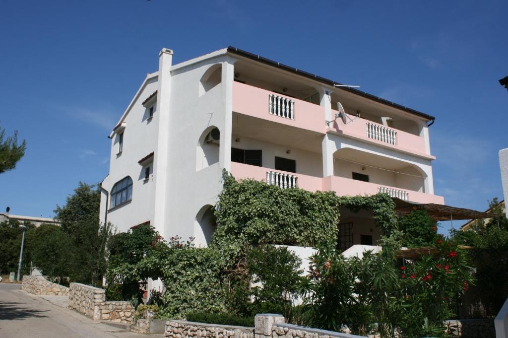 un gran edificio blanco con hiedra. en Apartments by the sea Mandre, Pag - 523, en Kolan