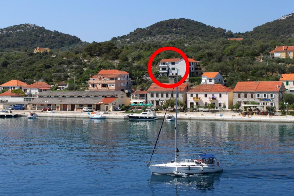 a sail boat in the water with a red circle at Apartments by the sea Sali, Dugi otok - 444 in Sali