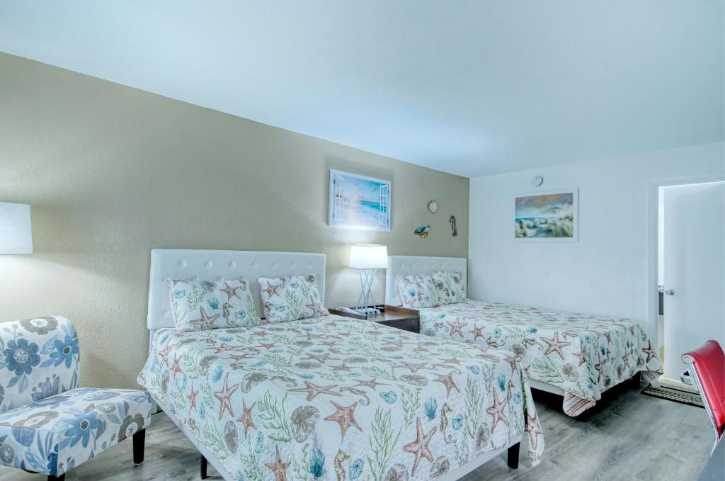 een hotelkamer met 2 bedden en een stoel bij All-New, First Floor, Bunk Bed, Huge Pool, 70 inch TV, Tiki Bar! in Sarasota