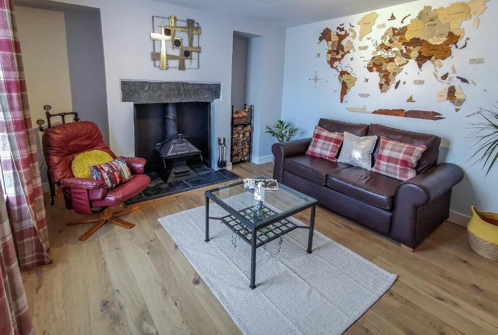 a living room with a couch and a fireplace at Kirkinner Cottage in Kirkinner