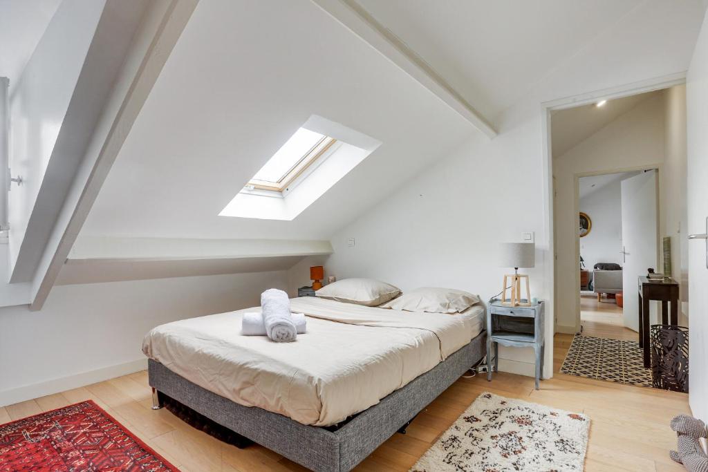 ein Schlafzimmer mit einem Bett und einem Dachfenster in der Unterkunft Le Marquis- Versailles in Versailles