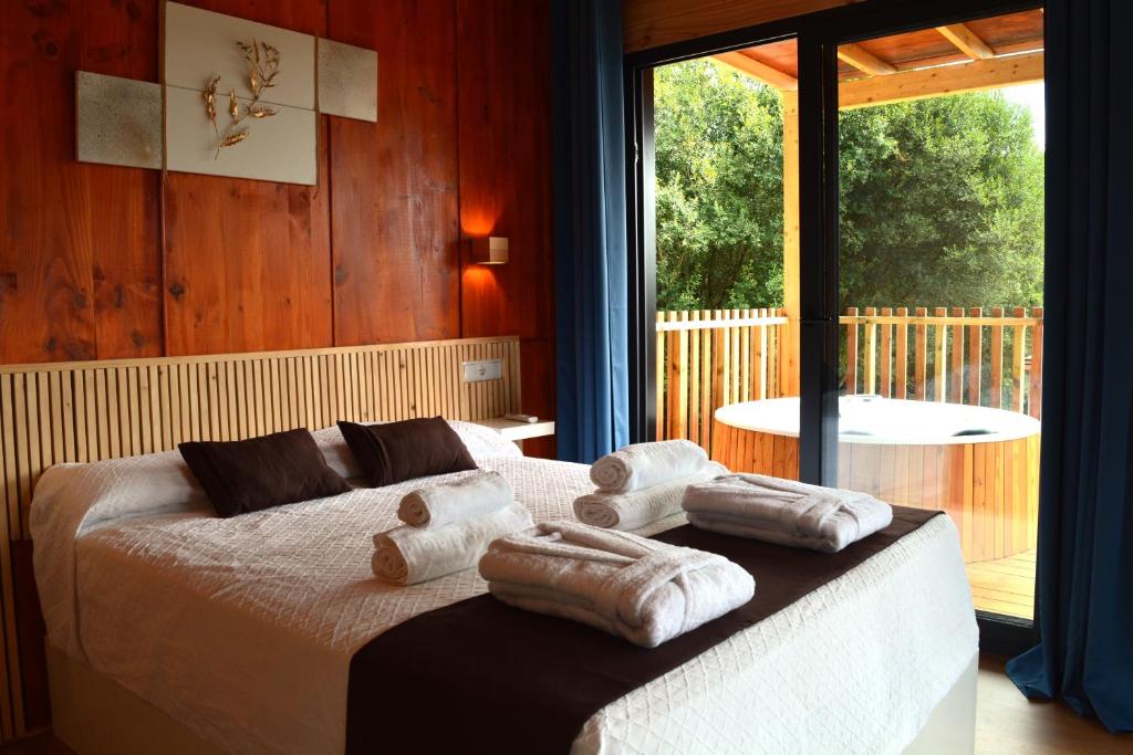 a bedroom with a bed with towels on it at Cabañas Compostela - Cabaña Pedroso con bañera de hidromasaje in Santiago de Compostela