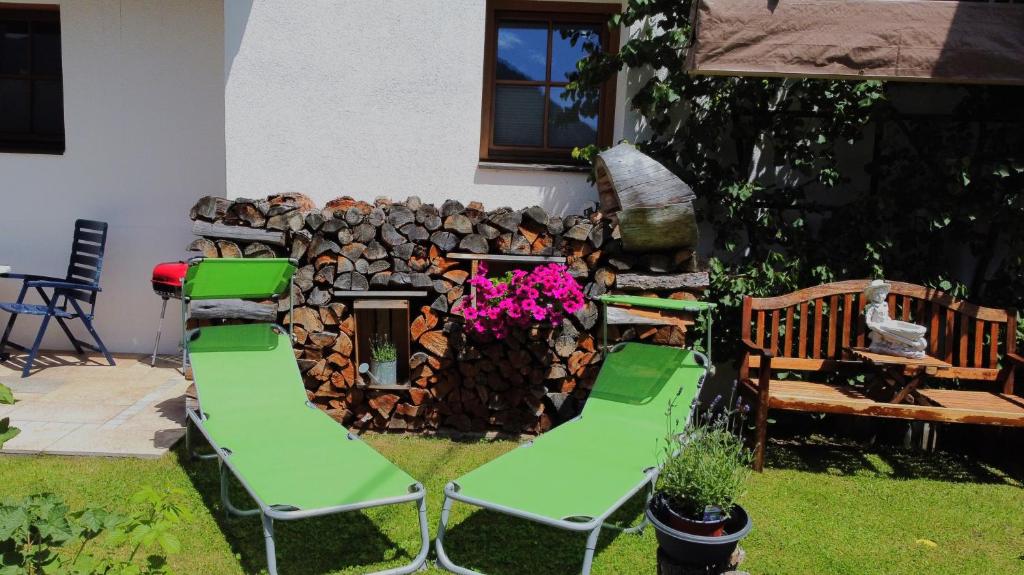 einen Garten mit zwei Gartenstühlen und einem Kamin in der Unterkunft Webershof in Umhausen
