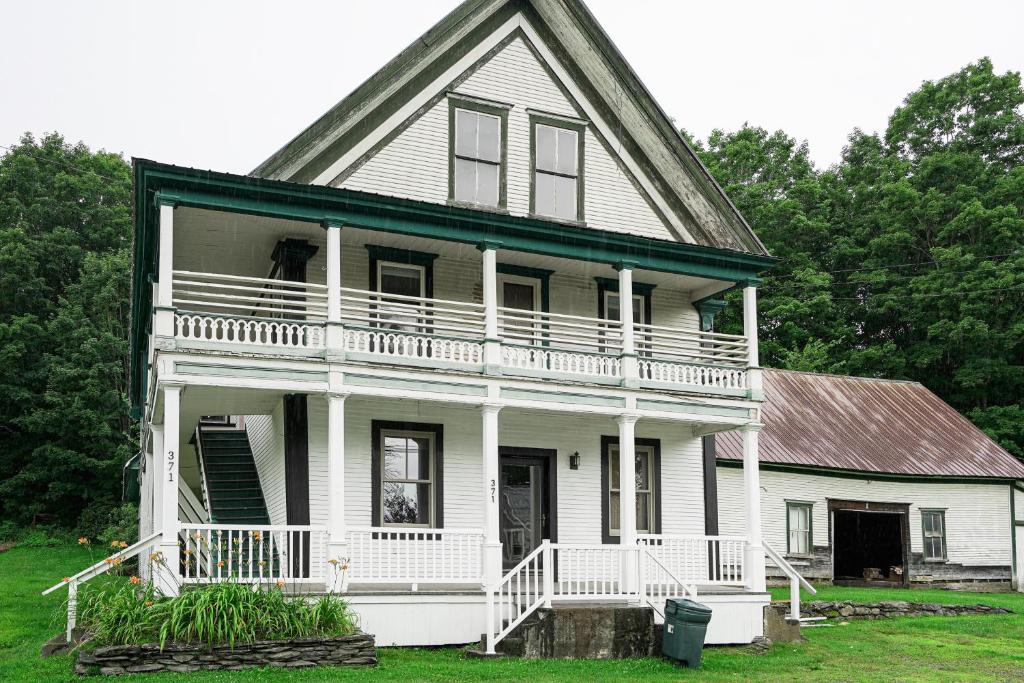 Cette ancienne maison blanche dispose d'une grande terrasse couverte et d'un balcon. dans l'établissement The General, à Lowell