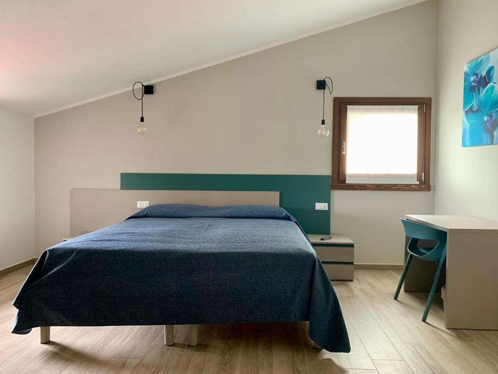 Schlafzimmer mit einem Bett, einem Schreibtisch und einem Fenster in der Unterkunft il Giglio B&B in Asola