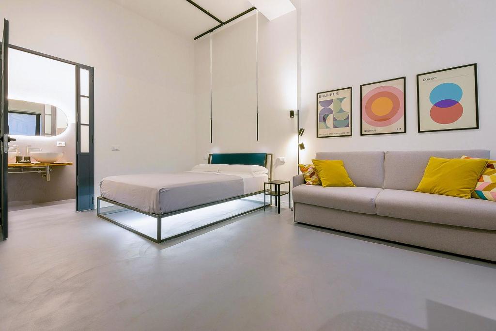 een woonkamer met een bank en een bed bij MONO Apartments in Bologna