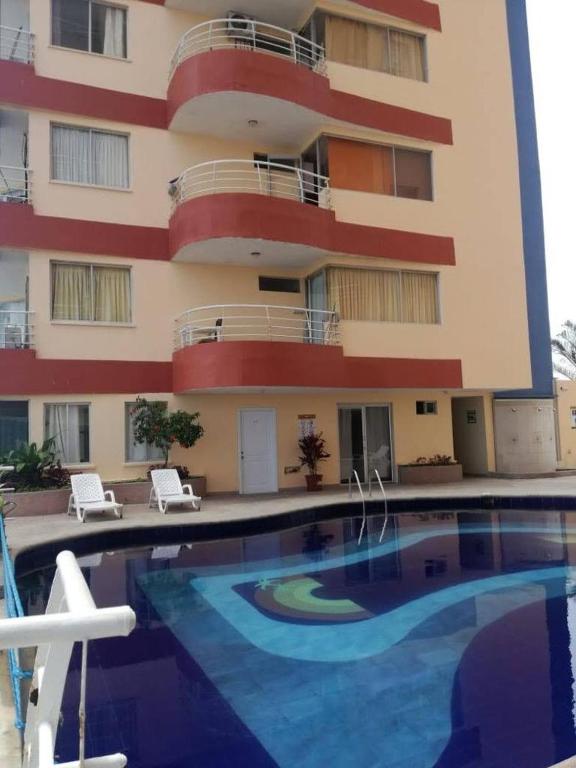 un hotel con piscina frente a un edificio en VACACIONES ARCO IRIS B−201, en Atacames