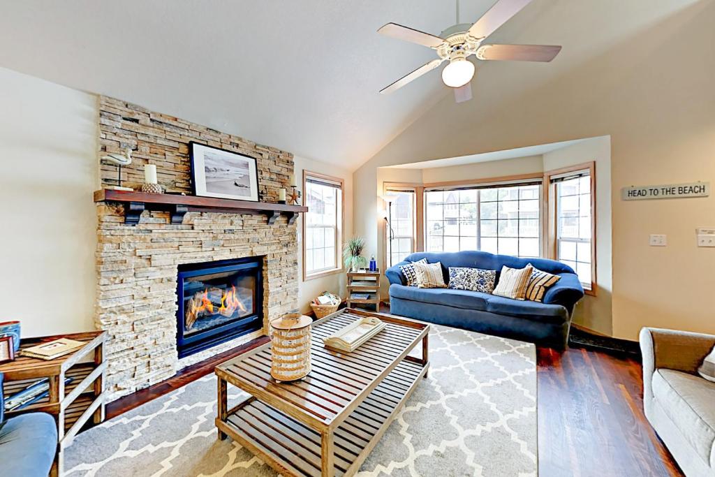 a living room with a fireplace and a blue couch at Oliver Beach House in Seaside