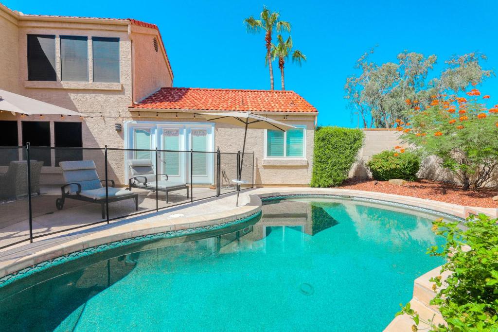 a swimming pool in front of a house at Poolside Getaway in Scottsdale