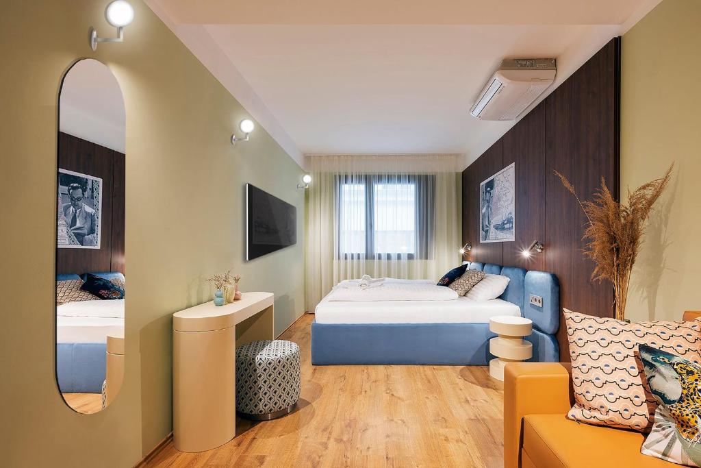 um quarto com uma cama, um espelho e um sofá em The Magazine Rooms em Budapeste