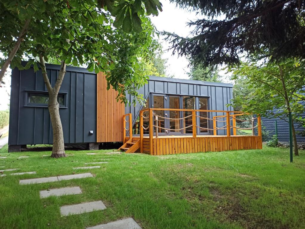 een tiny house met een speeltuin in een yard bij Domek na Pałukach 