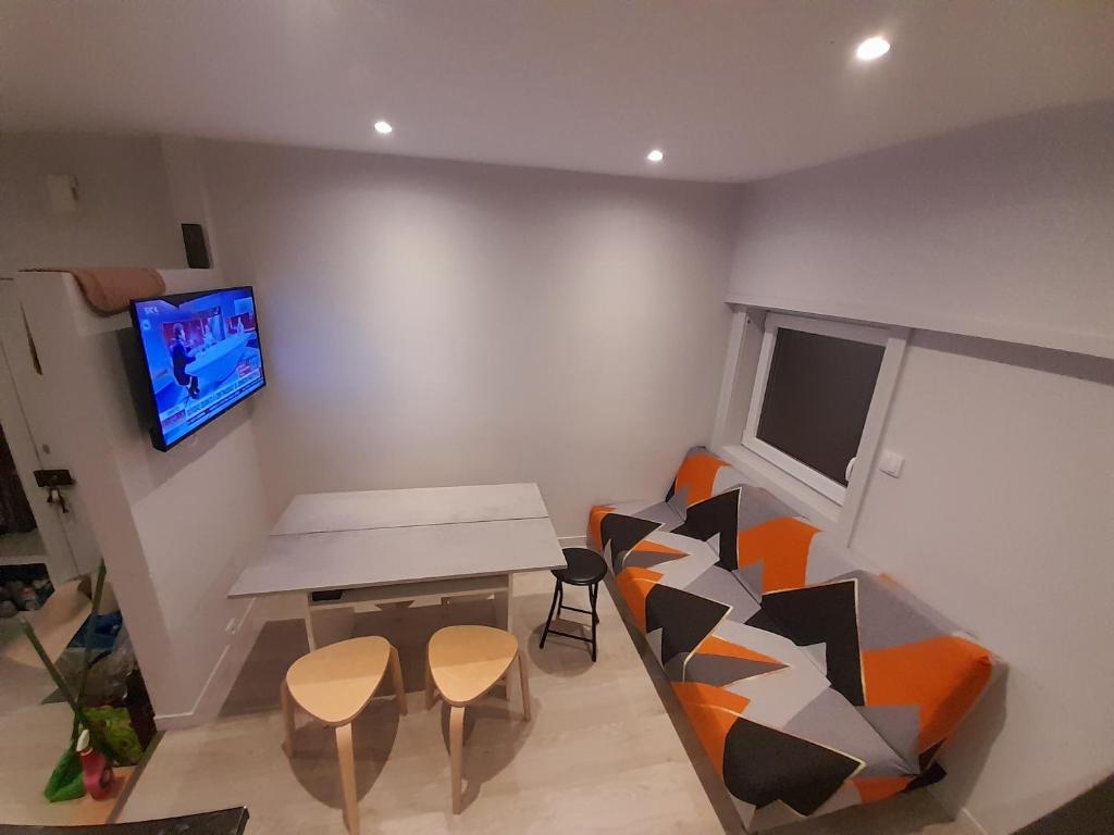 ein Wohnzimmer mit einem Tisch und Stühlen sowie einem TV in der Unterkunft OPO Downtown - cozy apartment @Oporto city center in Porto