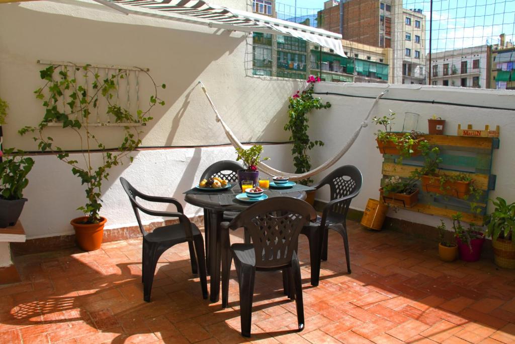 patio con mesa y sillas en el balcón en Casa Tortilla Sant Antoni, en Barcelona