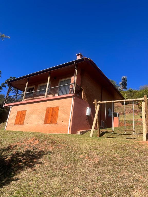 una casa con un balcón en el lateral. en Casa Bela vista, en Campos do Jordão