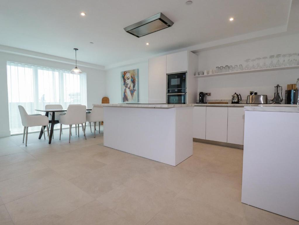 a kitchen and dining room with a table and chairs at 13 Cliff Edge in Newquay