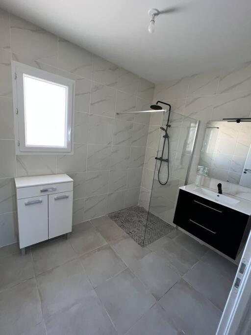 une salle de bain blanche avec une douche et un lavabo dans l'établissement Maison familiale contemporaine à Bergerac, à Bergerac