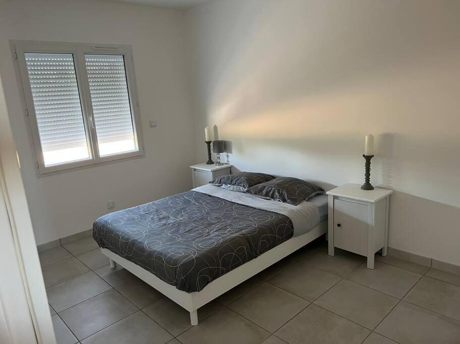 sypialnia z łóżkiem z 2 stolikami nocnymi i 2 oknami w obiekcie Maison familiale contemporaine neuve à Bergerac w mieście Bergerac