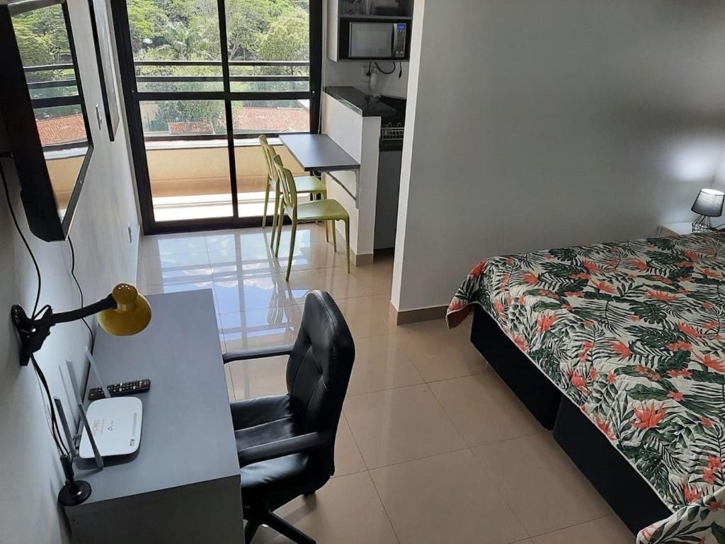 a hotel room with a bed and a desk and a chair at Ribeirania-Zeus 67-Garagem-WIFI-Pet Friendly in Ribeirão Preto