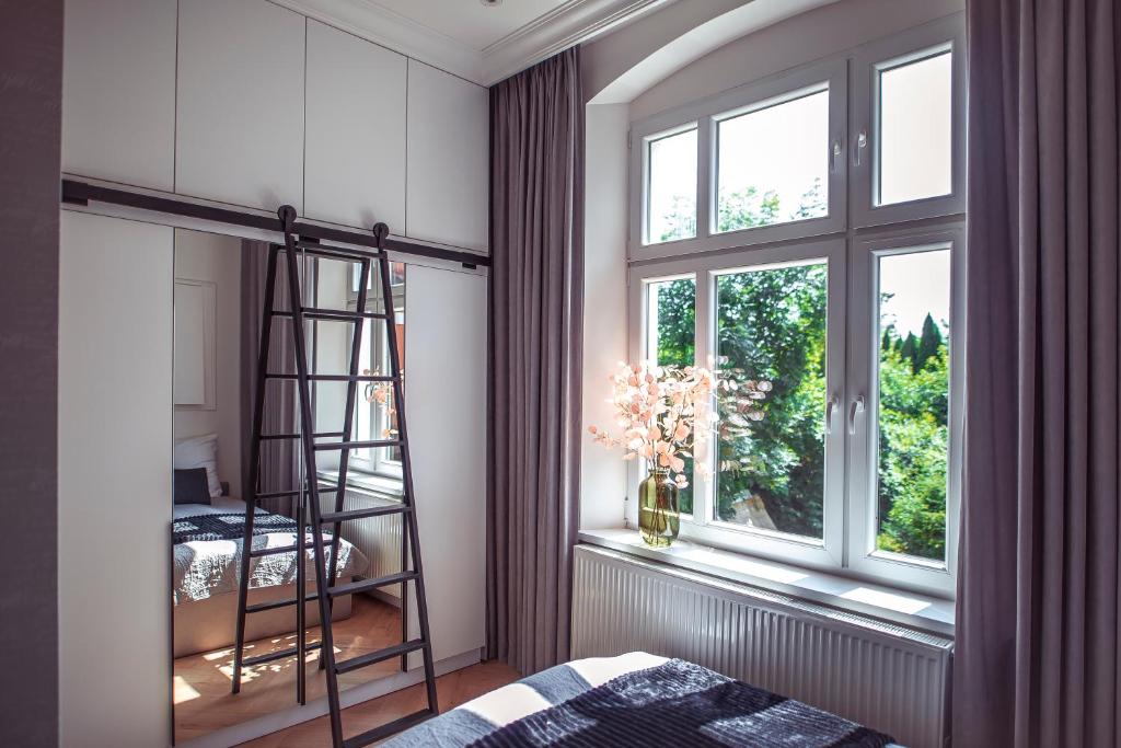 1 dormitorio con una escalera junto a una ventana en Apartments Kwidzyn en Kwidzyn