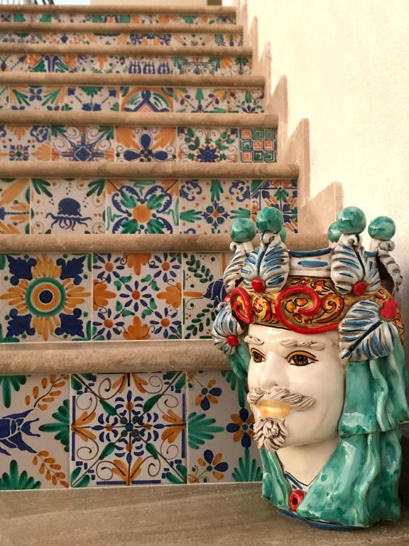 a statue of a face in front of some stairs at Le maioliche allo Stagnone kite in Marsala