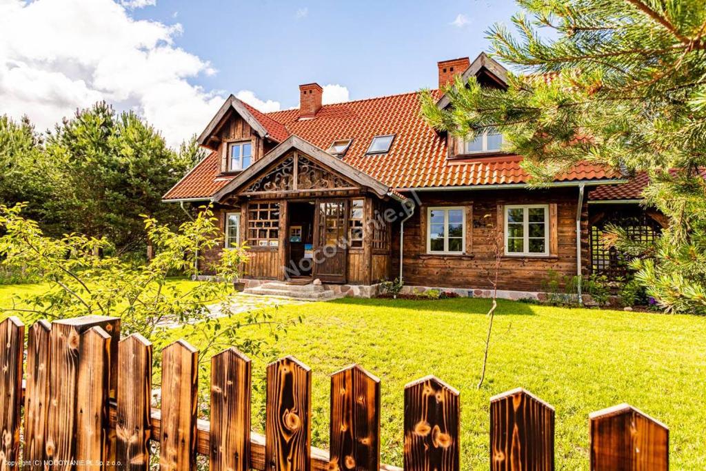 a wooden fence in front of a house at Dzika Róża Lubiatowo in Lubiatowo