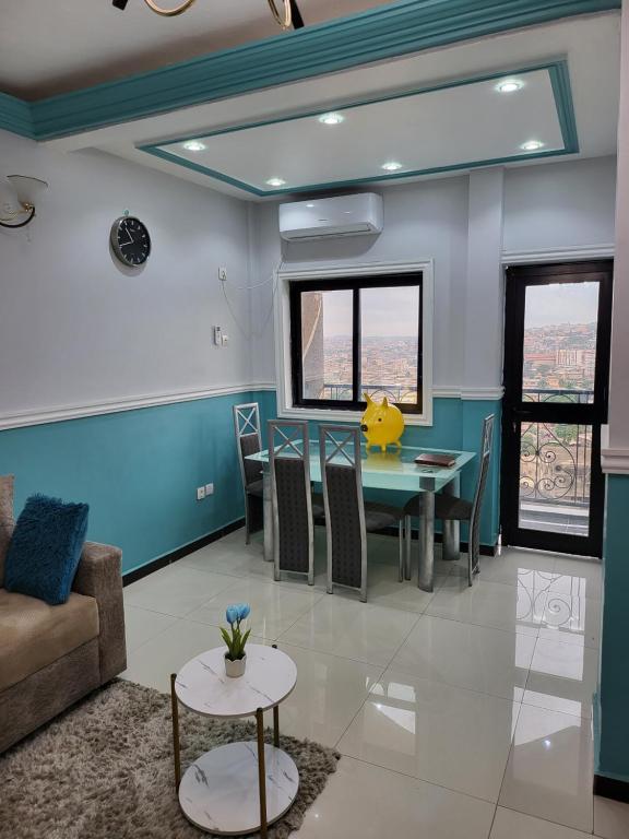 Lux Résidence في ياوندي: غرفة معيشة مع طاولة وأريكة
