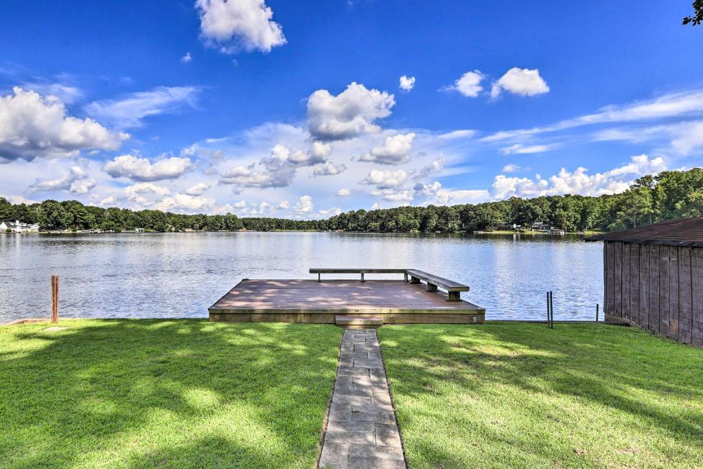 a dock on a lake with a bench on the grass at Lakefront Macon Getaway Grill, Pet Friendly! in Macon
