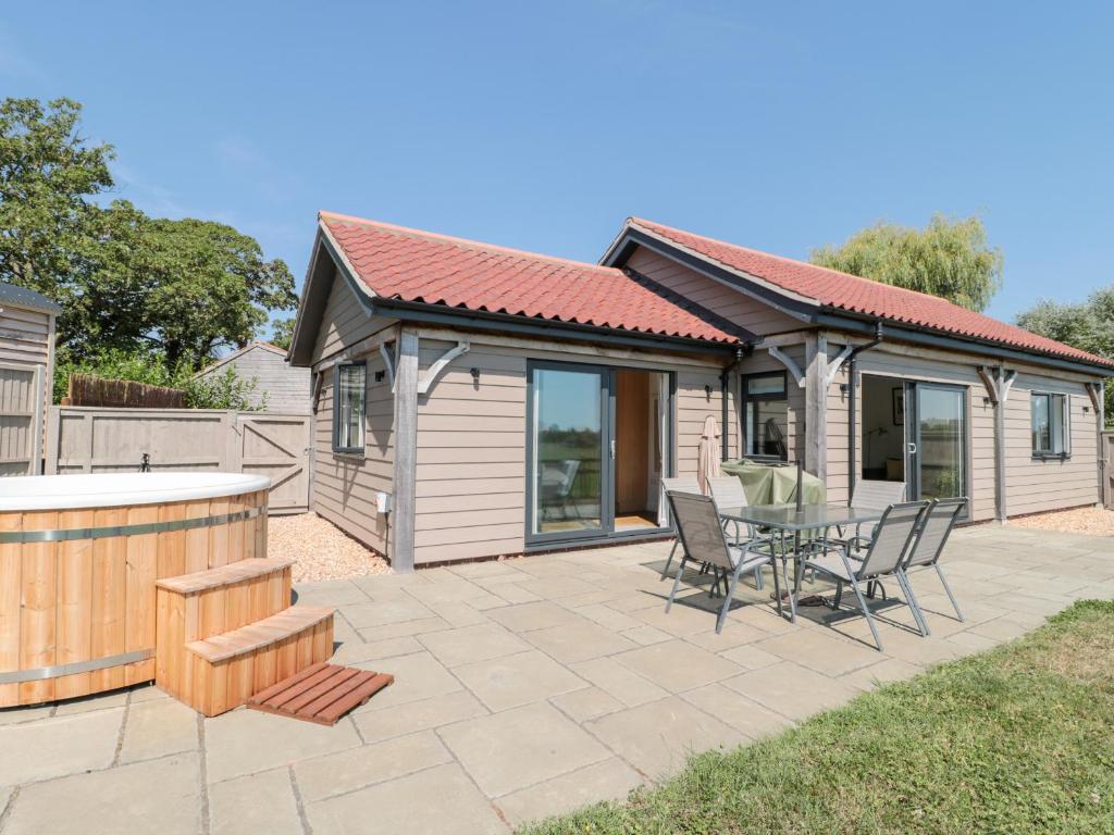 a house with a patio with a table and chairs at Robins Corner in Weston-super-Mare