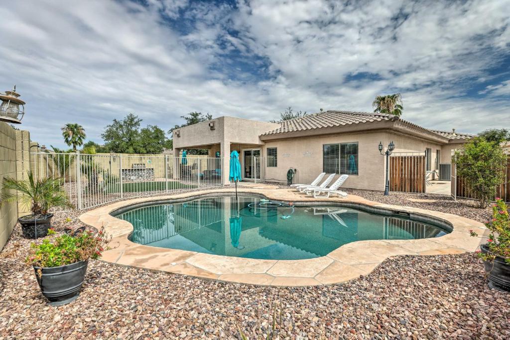 a swimming pool in front of a house at Goodyear Desert Oasis with Patio and Game Room! in Goodyear
