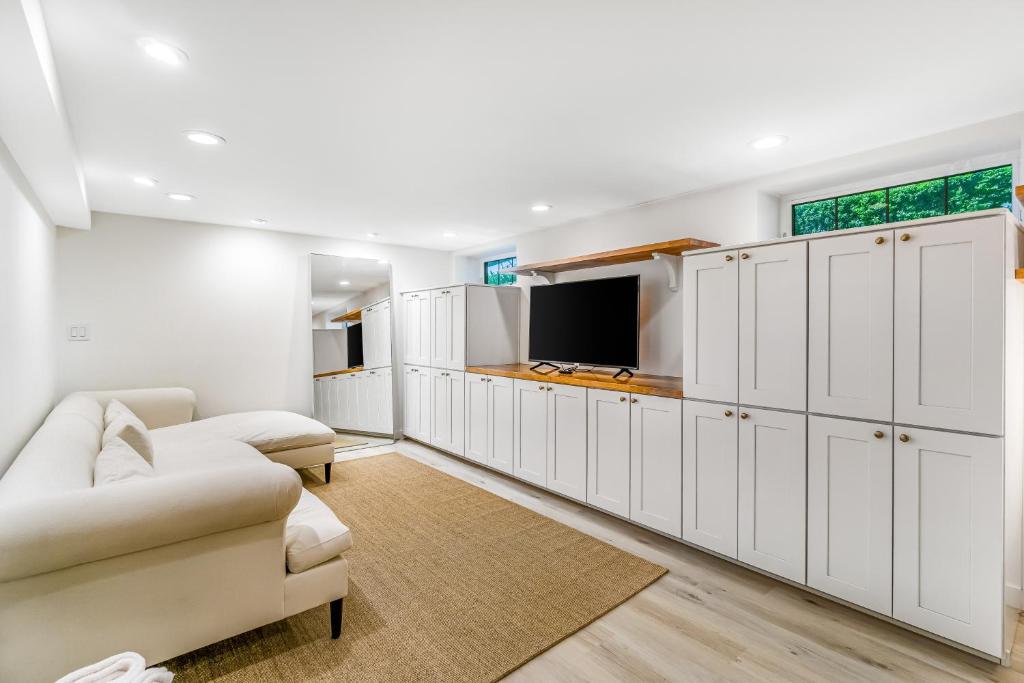 a living room with white cabinets and a tv at The Studio in Seattle