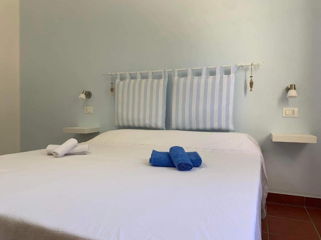- un lit blanc avec 2 serviettes bleues dans l'établissement Casa Simetite, à Granelli