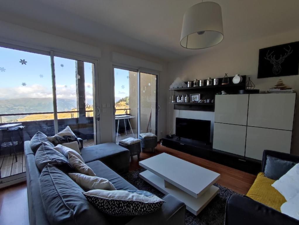 a living room with a couch and a table at Le Cosy Pyrénées pied de pistes Sérias in Germ