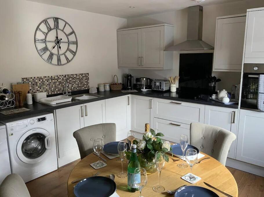 a kitchen with a table with chairs and a clock on the wall at St Marks Court Holiday Homes - No1 in Marske-by-the-Sea