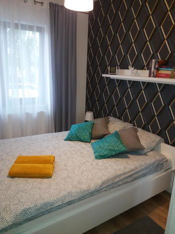 een slaapkamer met een bed met een gele handdoek erop bij Apartament Magda in Kołobrzeg