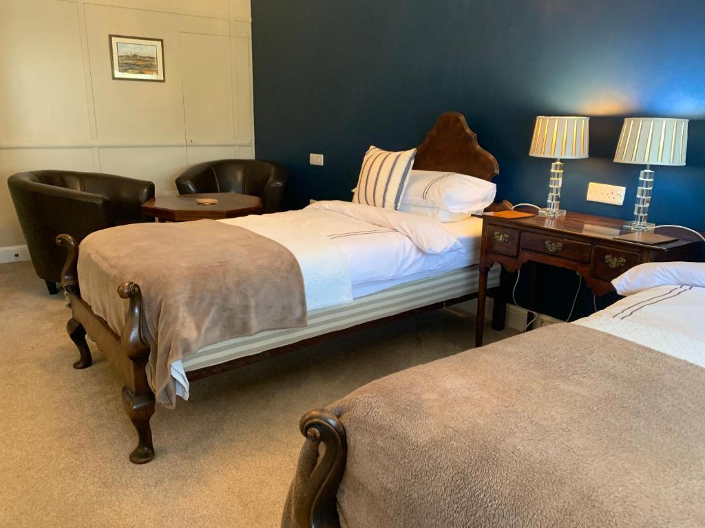 a hotel room with two beds and a desk and a bed at The Coast Yard B & B and Garden Chalets in Selsey